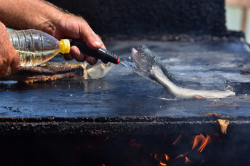 Cooking grilled fish on Vama Veche beach, a non-mainstream tourist destination on the Black Sea coast, near the border with Bulgaria, popular destination for tourists from entire world.