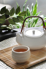Hot Tea with Tea Pot on Bamboo Mat
