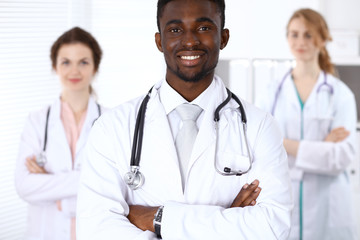 Happy african american male doctor  with medical staff at the hospital. Medicine concept
