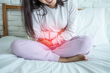woman have bladder pain sitting on bed in bedroom after wake up feeling so sick and painful,Healthcare concept