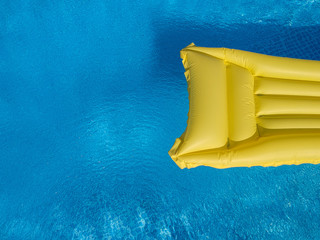 Top view of an inflatable mattress in a backyard swimming pool