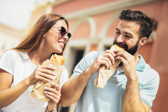 Young Couple Is Eating Sandwiches And Having A Great Time