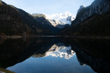 Fototapeta na wymiar In einem Bergsee spiegeln sich die umliegenden Gipfel im Hintergrund leuchtet der Gletscher