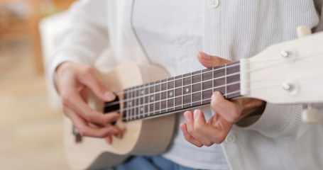 Fototapeta na wymiar Woman play a music on ukulele
