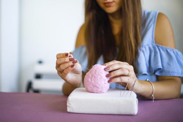young caucasian woman making wool dry felting tutorial. female showing needle felted toy master class. Hobbies, handmade, crafting, leisure, teaching, education, creativity, design concept