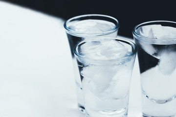 Vodka shots with ice on a white background
