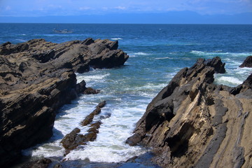 Fototapeta na wymiar 城ヶ島の岩場に打ち寄せる波