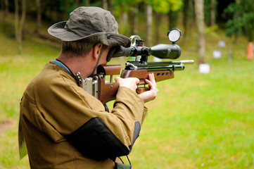man shooting a target with an air rifle
