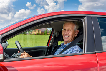 Fototapeta na wymiar Cheerful old man car driver, in the countryside.