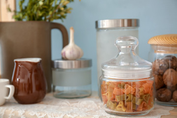 Fototapeta na wymiar Glass jar with pasta on shelf indoors