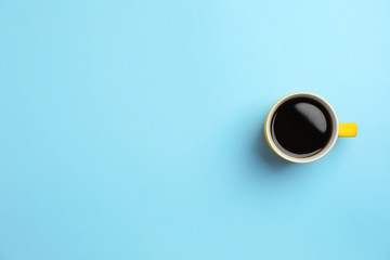 Ceramic cup with hot aromatic coffee on color background, top view