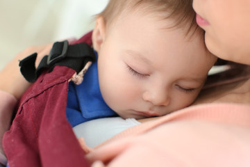 Loving mother with baby in ergo carrier, closeup