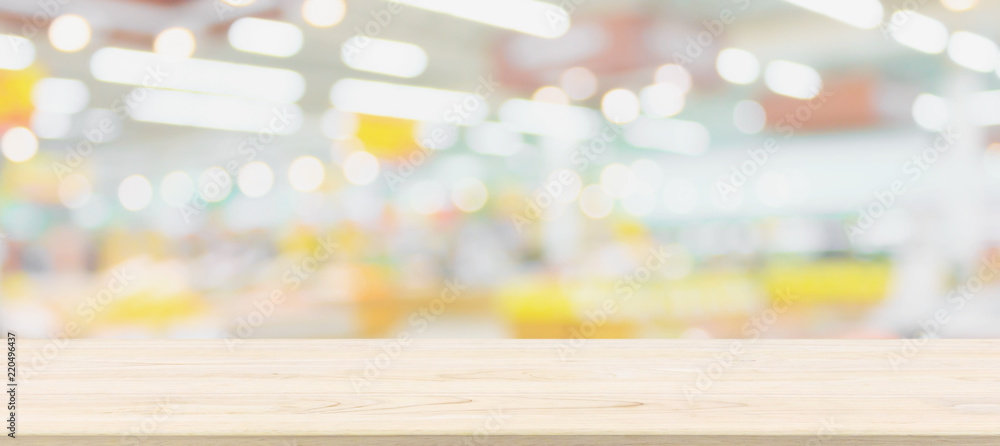 Wall mural wood table top with blur grocery store background with bokeh light