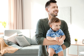 Handsome dad with his little son at home