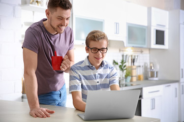 Teenager with father doing homework at home