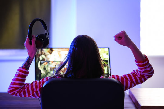 Young woman with headphones playing video games at tournament