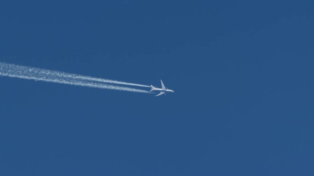 airplane and inversion trails against the blue sky