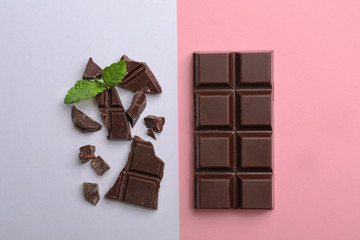 Flat lay composition with chocolate and mint on color background