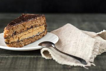 Tasty piece of chocolate cake on wooden table background