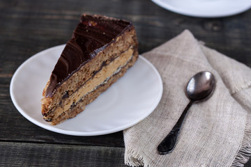 Tasty piece of chocolate cake on wooden table background