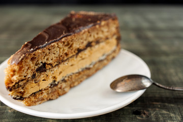 Tasty piece of chocolate cake on wooden table background