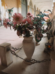 Certosa monumental cemetery, Ferrara, Italy. Flower vases and Renaissance colonnade with gravestones.