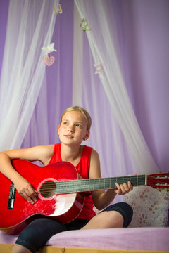 Teenage girl with her guitar in her lovely room&uml;
