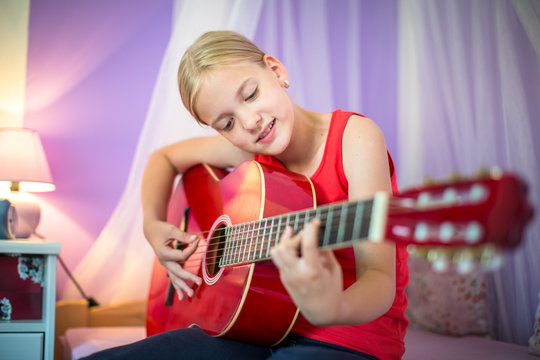 Teenage girl with her guitar in her lovely room¨
