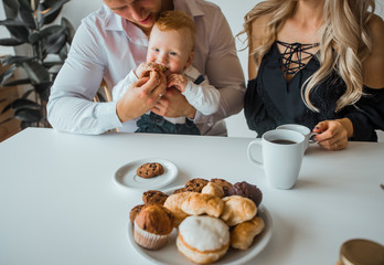 Obraz na płótnie Canvas Photo of amazing young loving couple parents with their little baby son. Breakfast for a young family and their little son