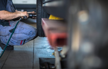 Wheel change - balancing/repairing wheels on a modern car in a garage/auto service by a mechanic