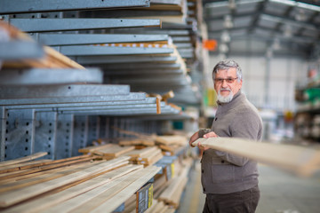 DIY concept -Senior man choosing and buying construction wood in a DIY store for his DIY home re-modeling project