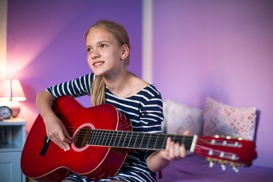 Teenage girl with her guitar in her lovely room&uml;