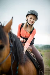 Foto op Canvas Cute young girl riding a horse © lightpoet