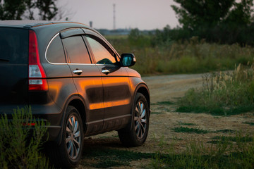 Fototapeta na wymiar Angle shot of a car against sunset in the background