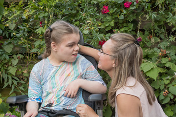 Disability a disabled child learning and communicating with help from a special needs care assistant