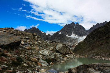 Fototapeta na wymiar Lago di montagna con vista cime e cielo azzurro