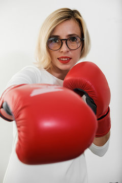 young woman with red boxing gloves. Girl in red dress are fighting, attacking and protecting.  Feminism, girl power, fight like girl, gender, woman rights concept