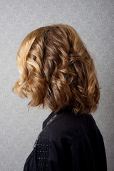 Female hairstyle short locks on the head brown-haired back view close-up.