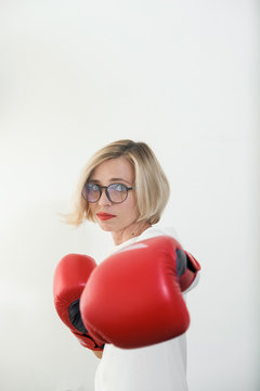 young woman with red boxing gloves. Girl in red dress are fighting, attacking and protecting.  Feminism, girl power, fight like girl, gender, woman rights concept