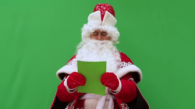 Father Frost holds the form. The New Year's character holds the A4 format model. Green background. An opportunity to insert the design.