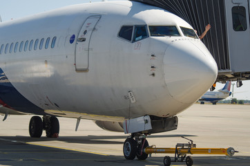 A pilot is waving from the cockpit while boarding. Closeup of the plane before taking off. Pilot is waving with his hand out of the window of cockpit.
