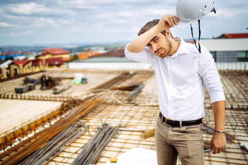 Portrait of architect on construction site with hardhat.