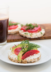 Crisp breads with cheese, tomatoes, avocado and coffee