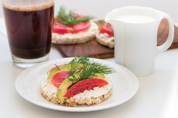 Crisp breads with cheese, tomatoes, avocado and coffee