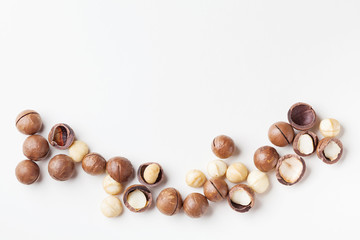 Obraz na płótnie Canvas Organic macadamia nuts on white table from above.