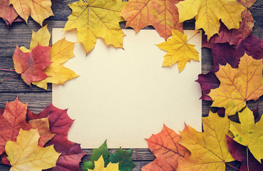 Naklejka na ściany i meble Frame of autumn leaves on wooden background