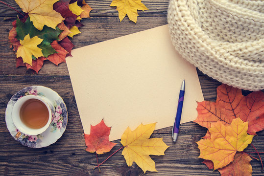 Toned picture with autumn leaves, a cup of tea and a notebook
