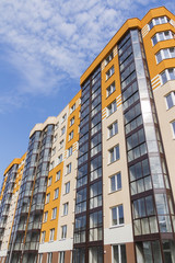 Modern apartment building in sunny day against blue sky.