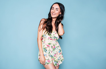 Photo of beautiful young woman in colorful dress isolated on blue background