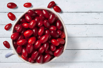 A bowl of mature dogwood on an old table.  View from above